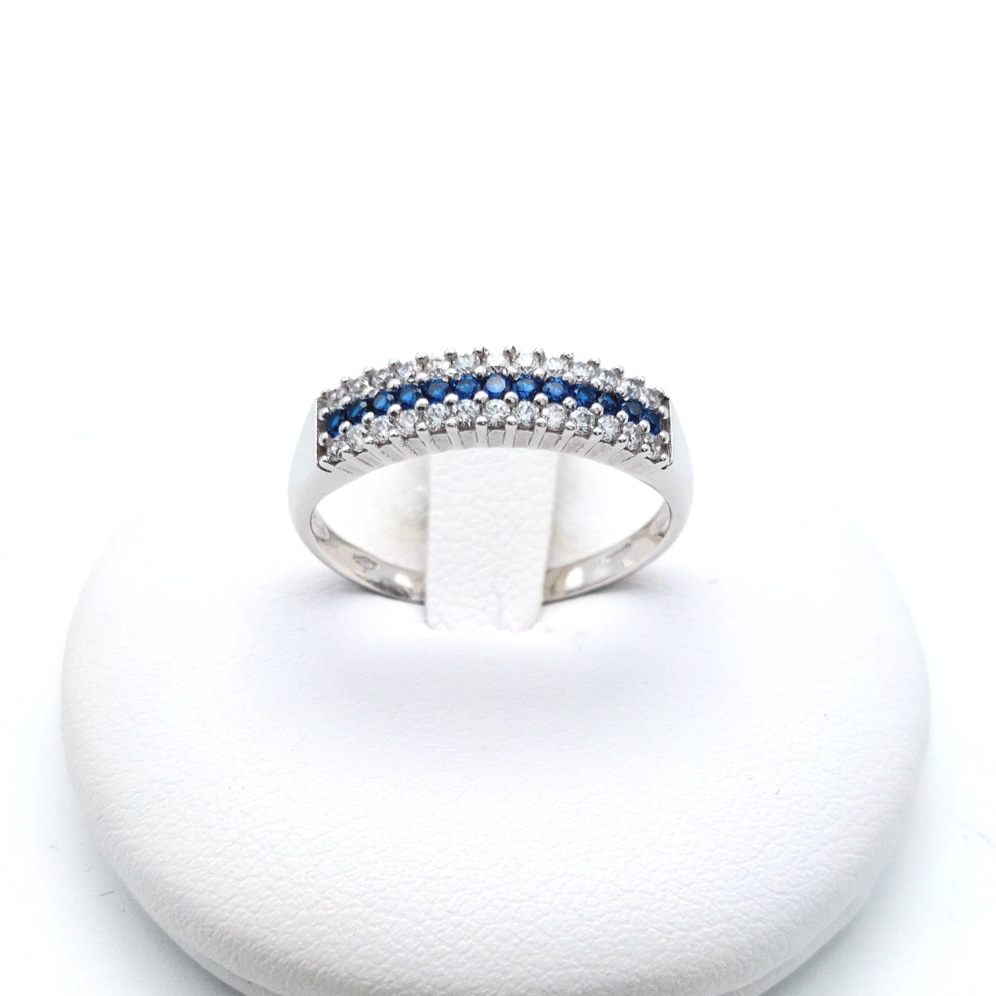 Anello mezza veretta a 3 fili di zirconi bianchi e blu in oro bianco 18 KT. AN-ORO097.