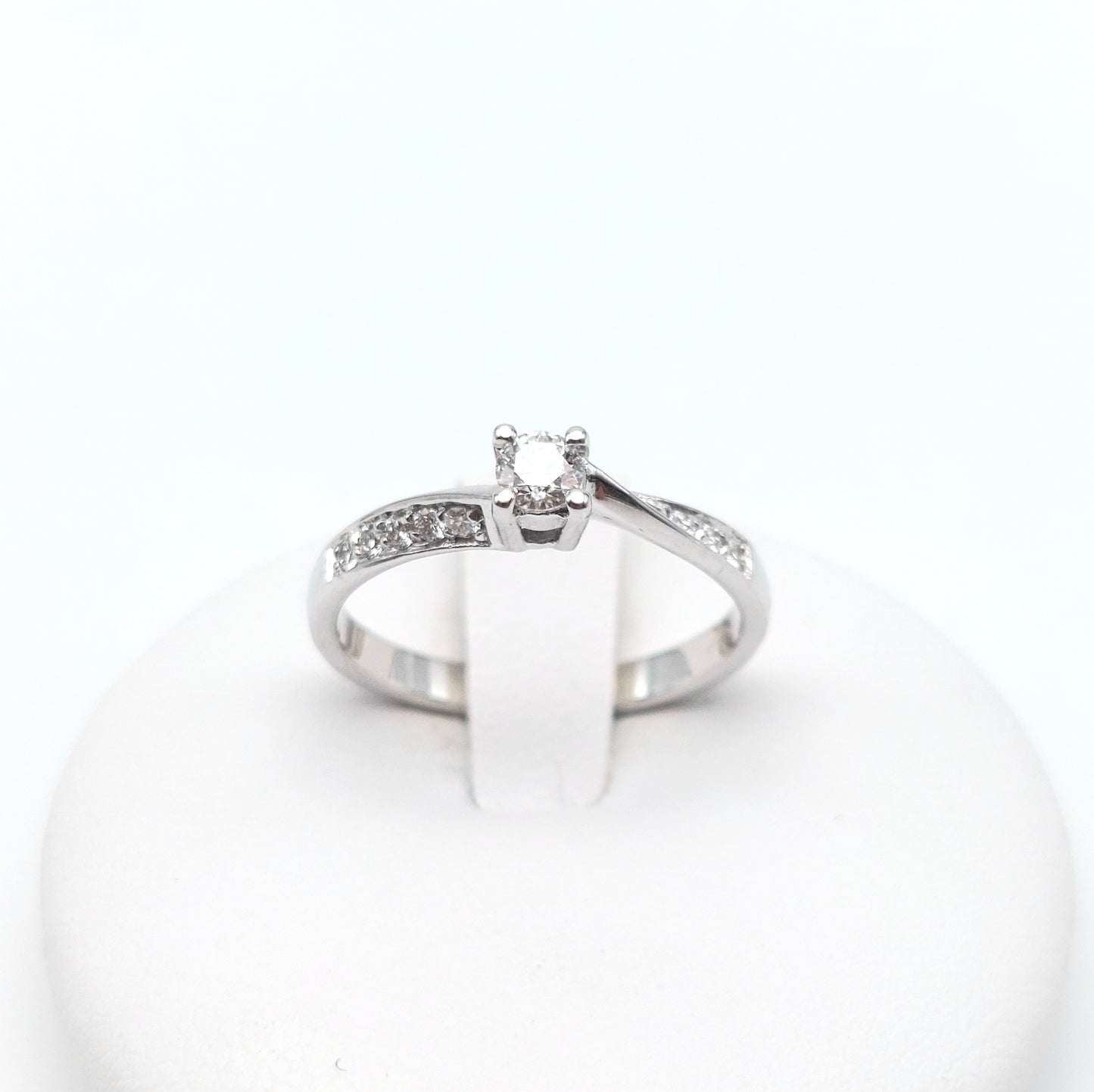 Anello solitario con brillanti laterali in oro bianco 18 carati. AN-BR-D025.