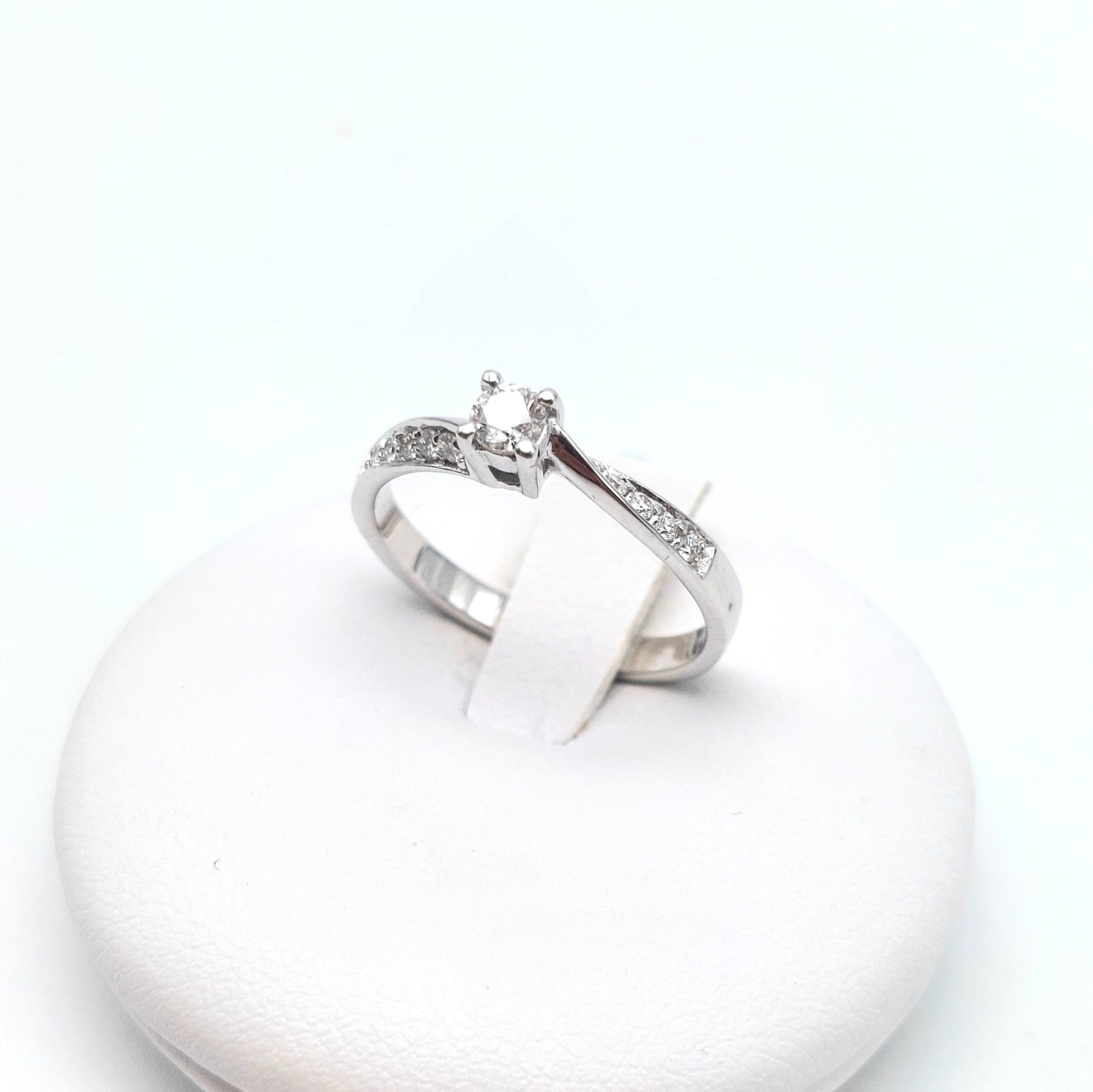 Anello solitario con brillanti laterali in oro bianco 18 carati. AN-BR-D025.