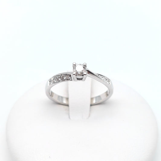Anello solitario con brillanti laterali in oro bianco 18 carati. AN-BR-D025.