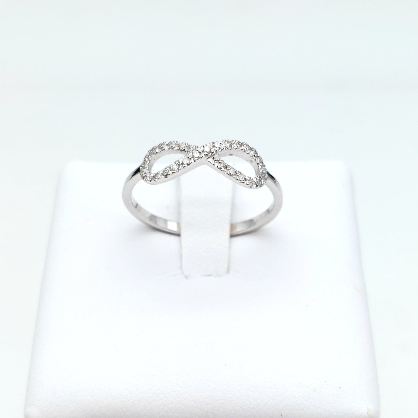 Anello simbolo infinito in oro bianco 18 carati con diamanti naturali. AN-BR-D034.