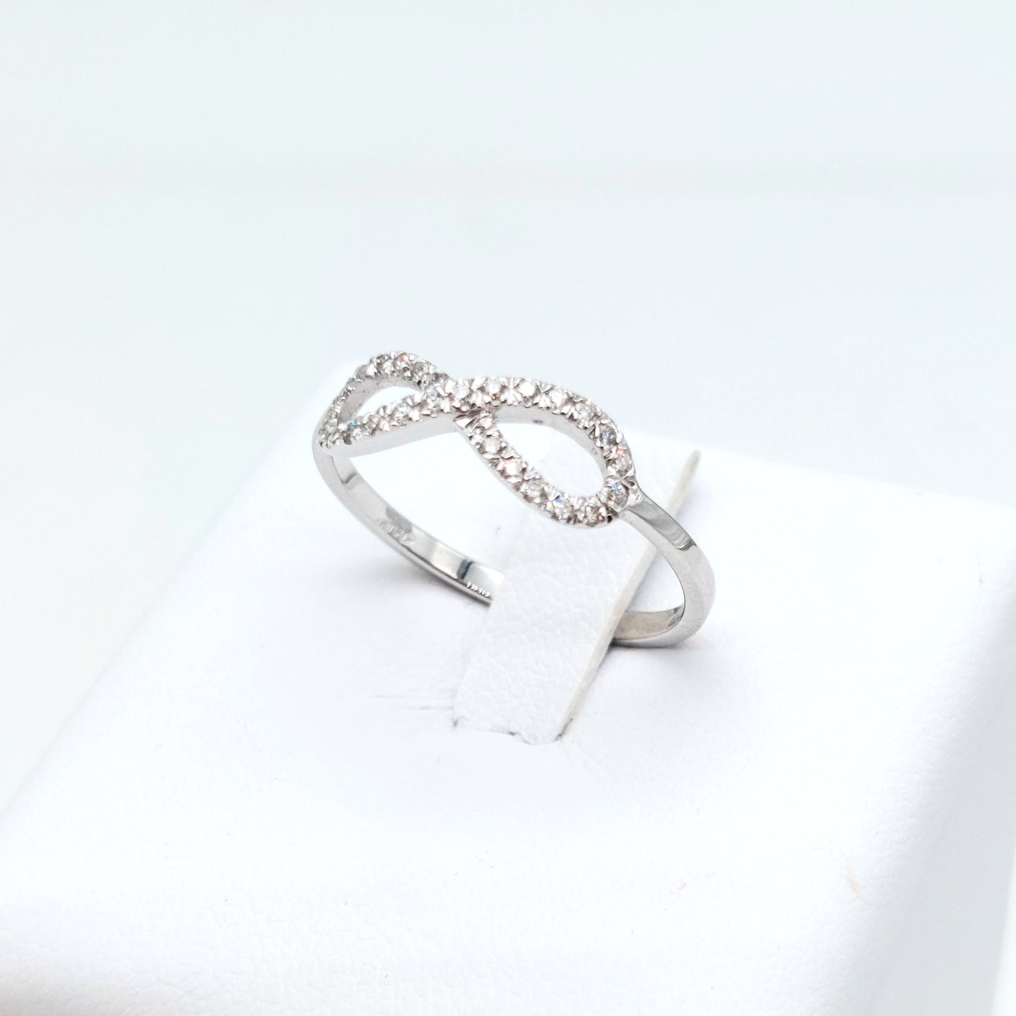 Anello simbolo infinito in oro bianco 18 carati con diamanti naturali. AN-BR-D034.